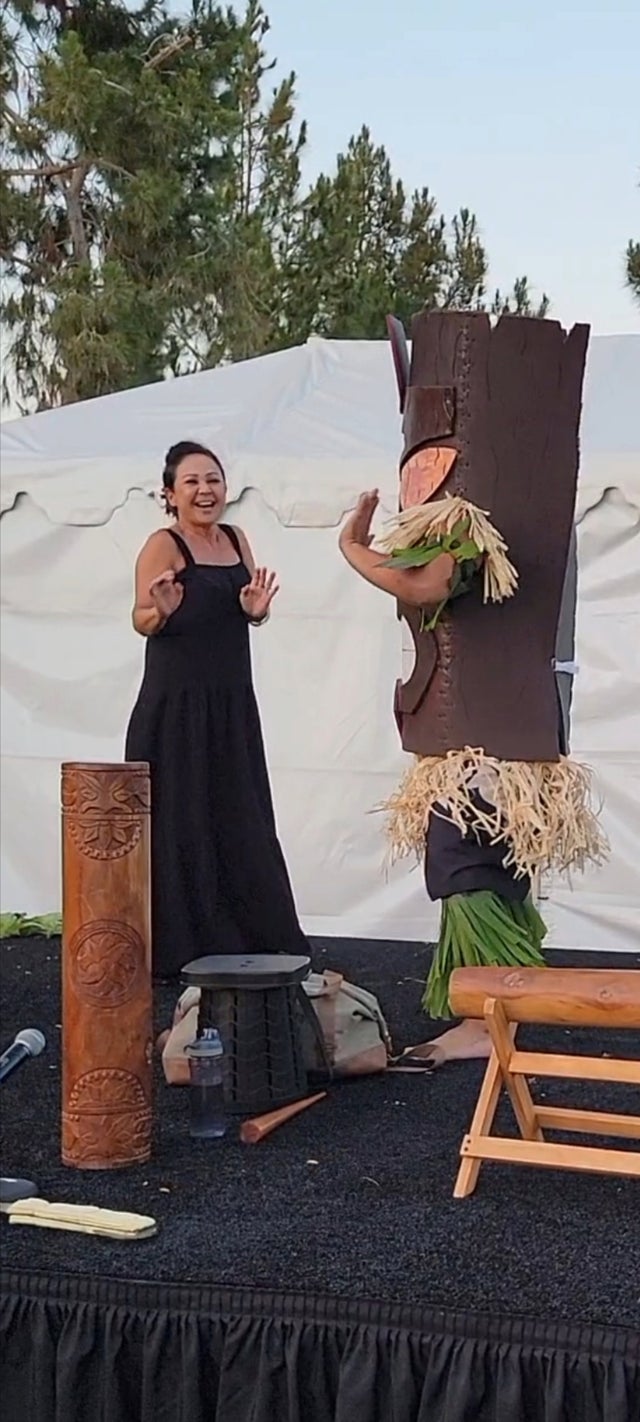 Polynesian hula dancer performing on stage in tropical costume