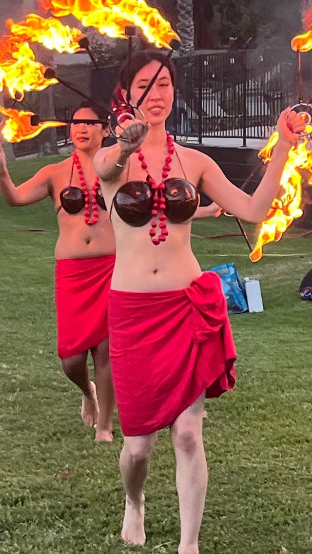 Fire dancer performer spinning flames at a dramatic night show